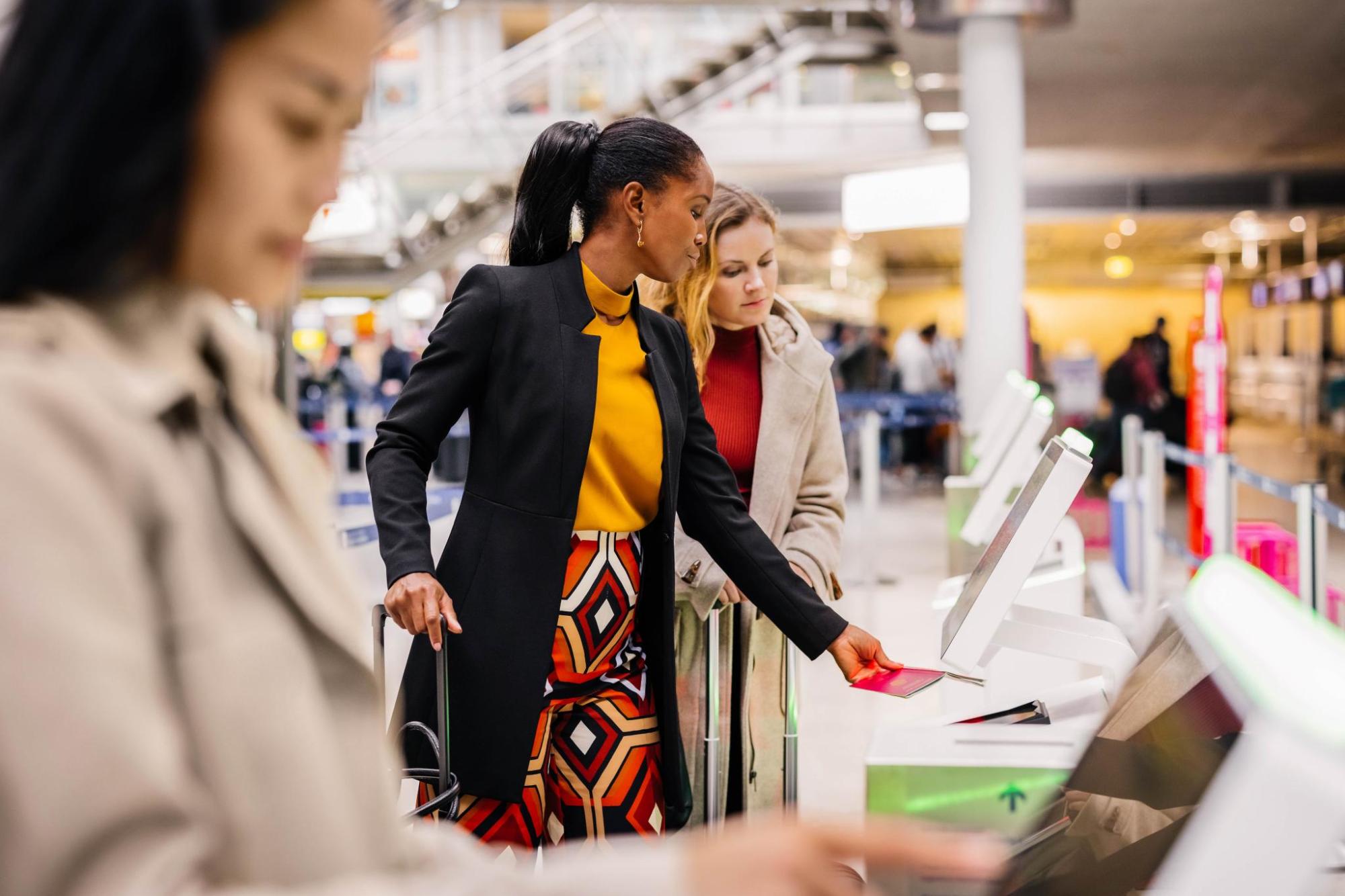 A woman scans her passport at a self service kiosk