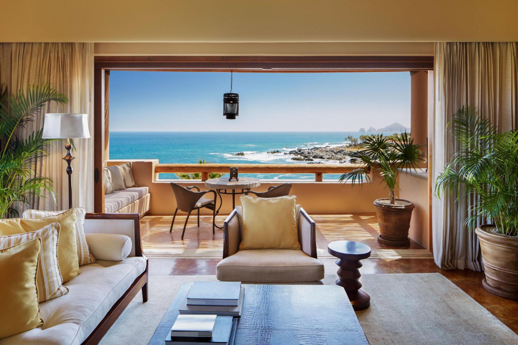 An elegant resort suite opens onto a private balcony overlooking the coastline