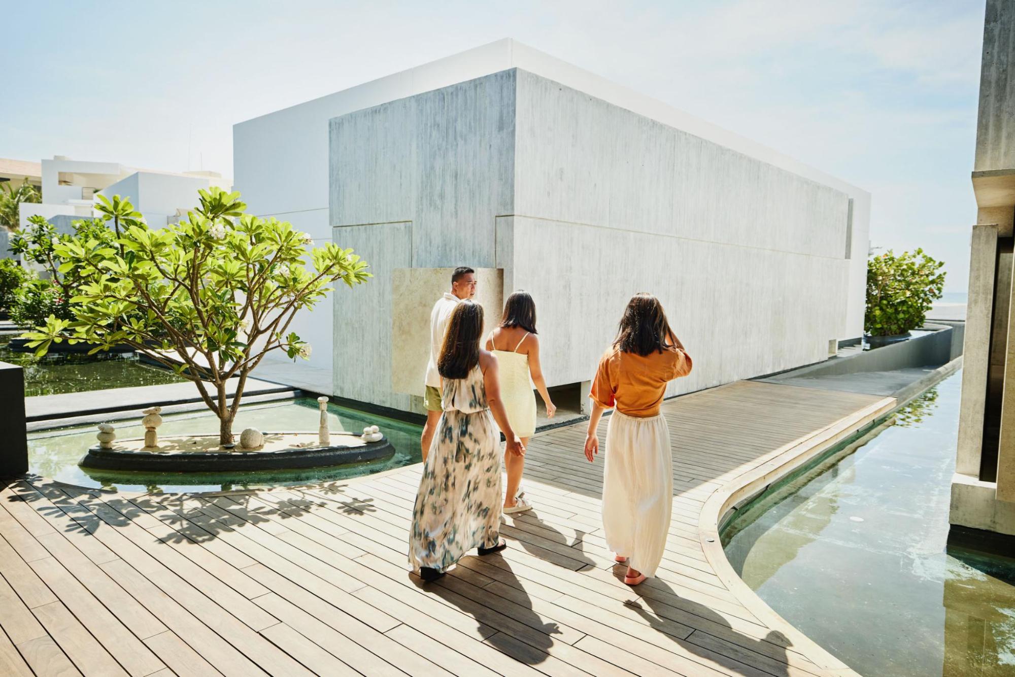 A group of friends walking toward a modern holiday home
