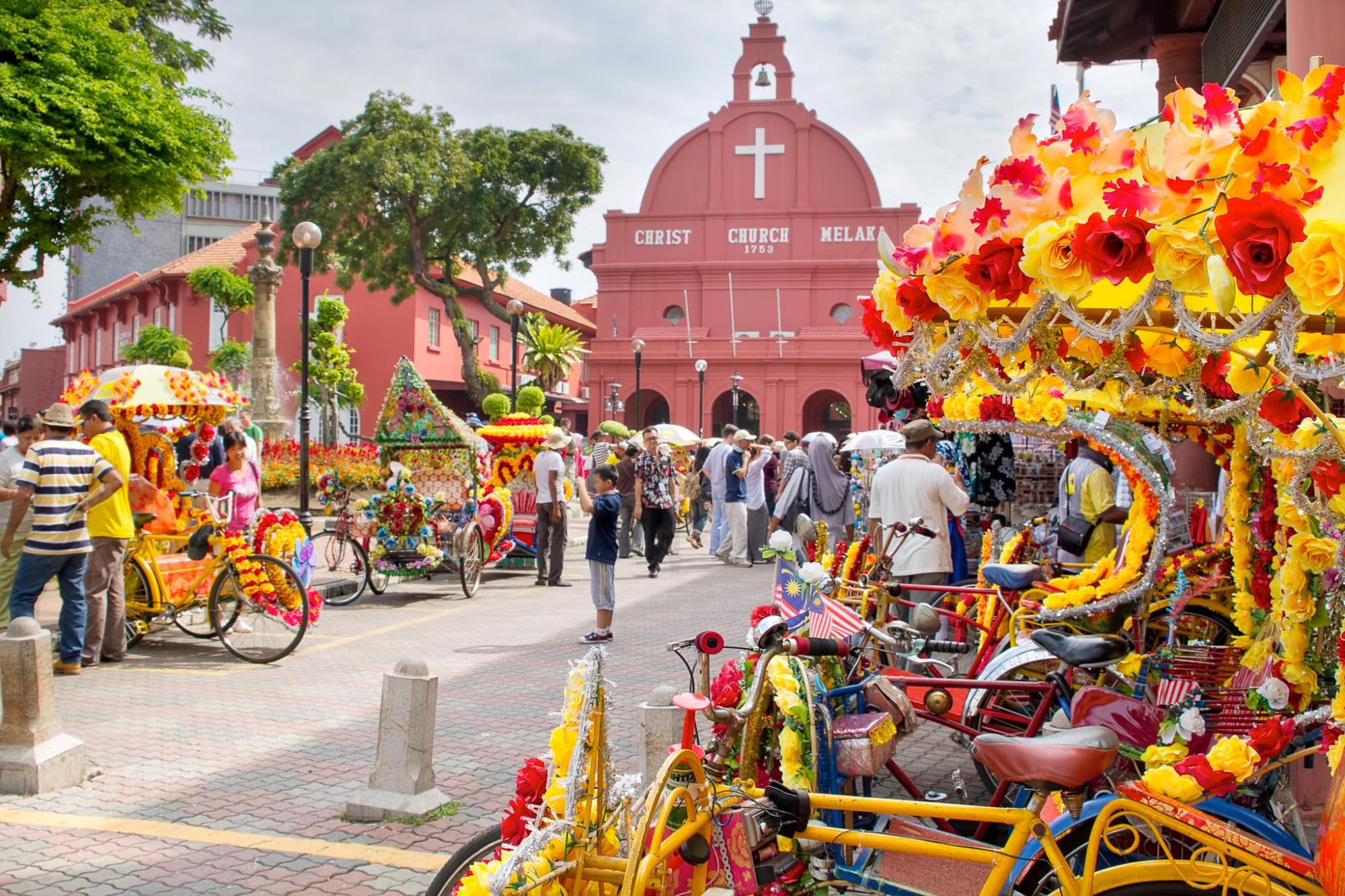 Colourful decorated trishaws outside Christ Church in Melaka.