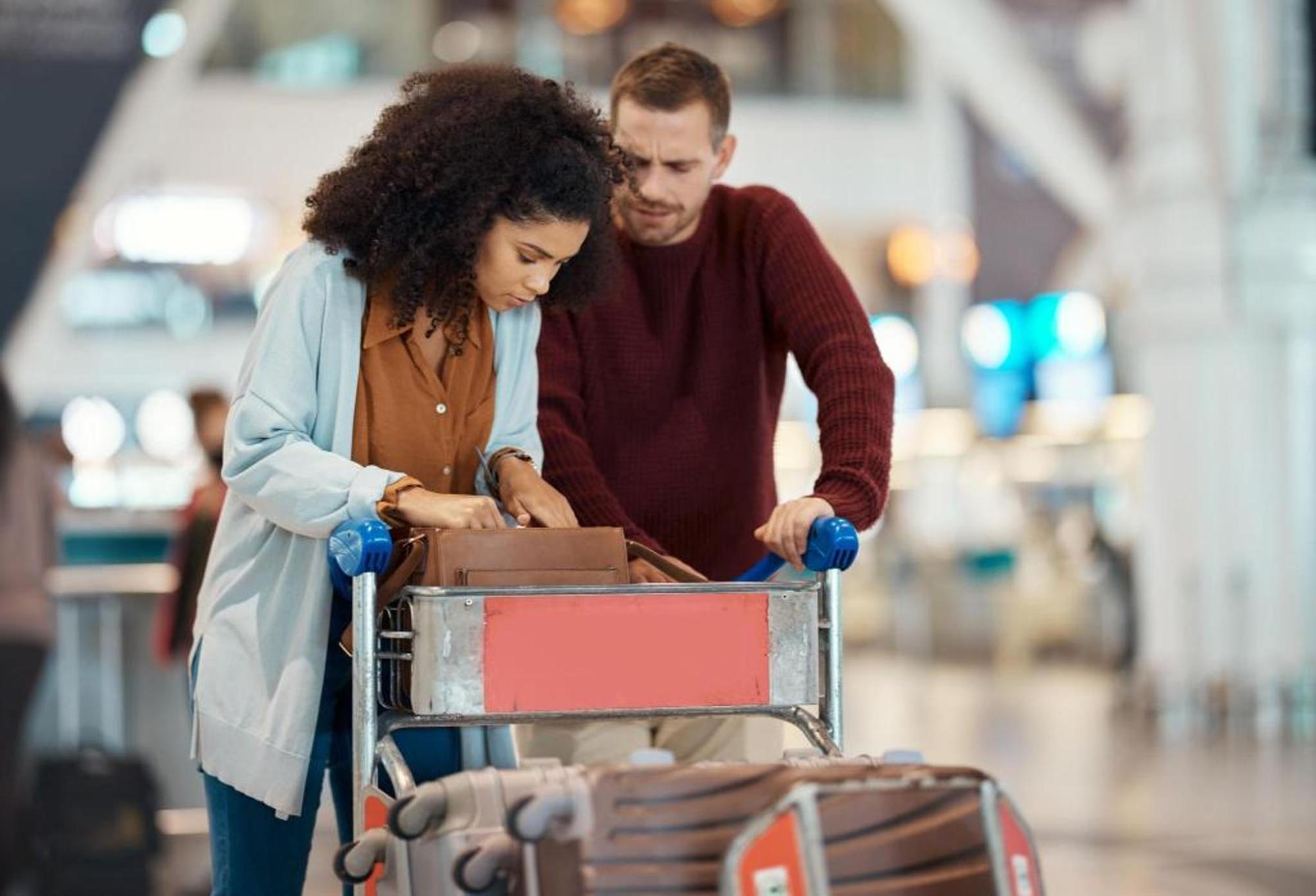 A couple searching through a purse at the airport