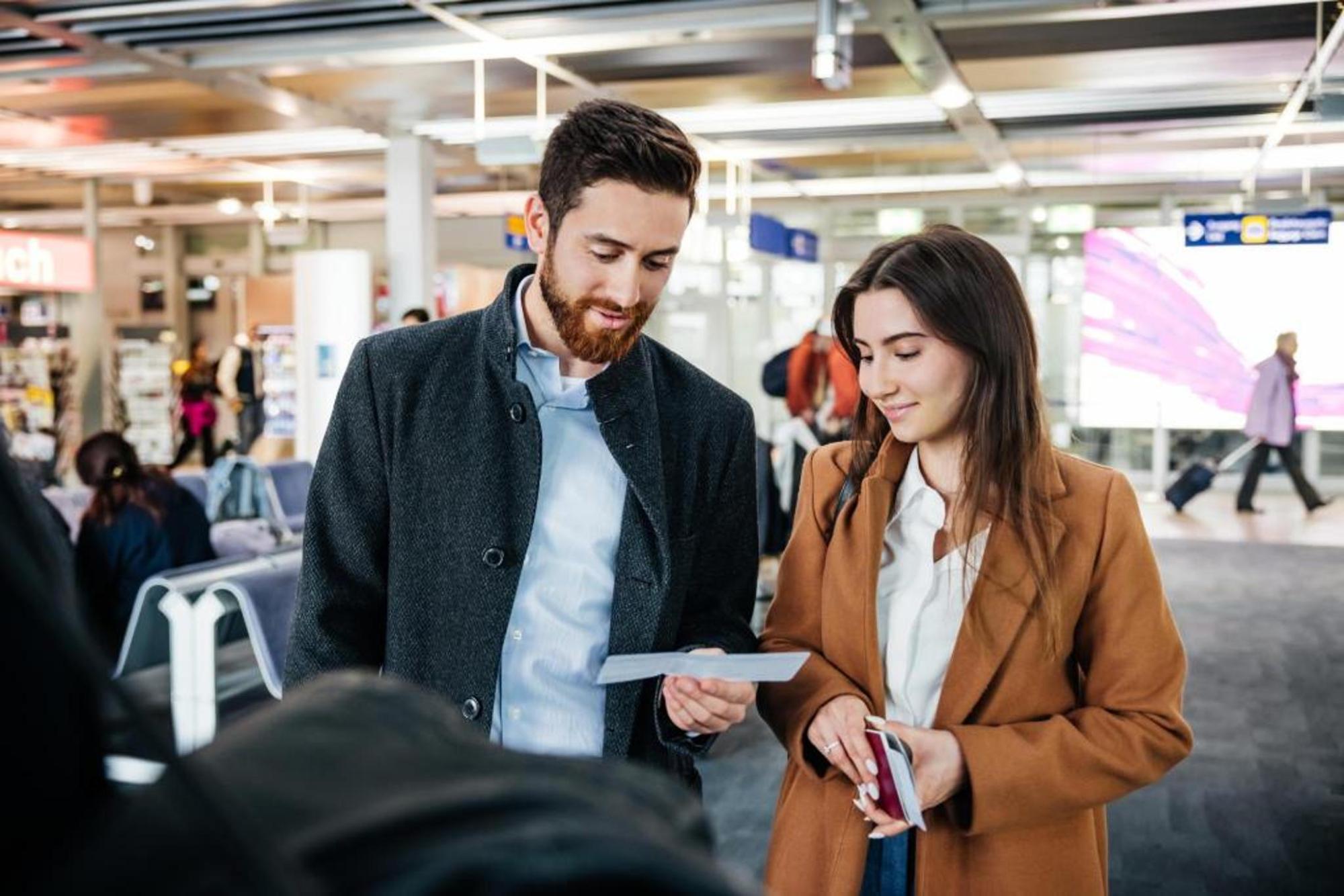 A couple at the airport, inspecting their boarding pass