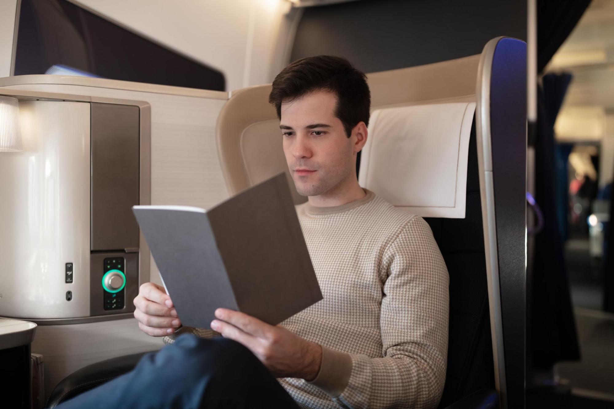 Man reading a menu while enjoying a first-class flight