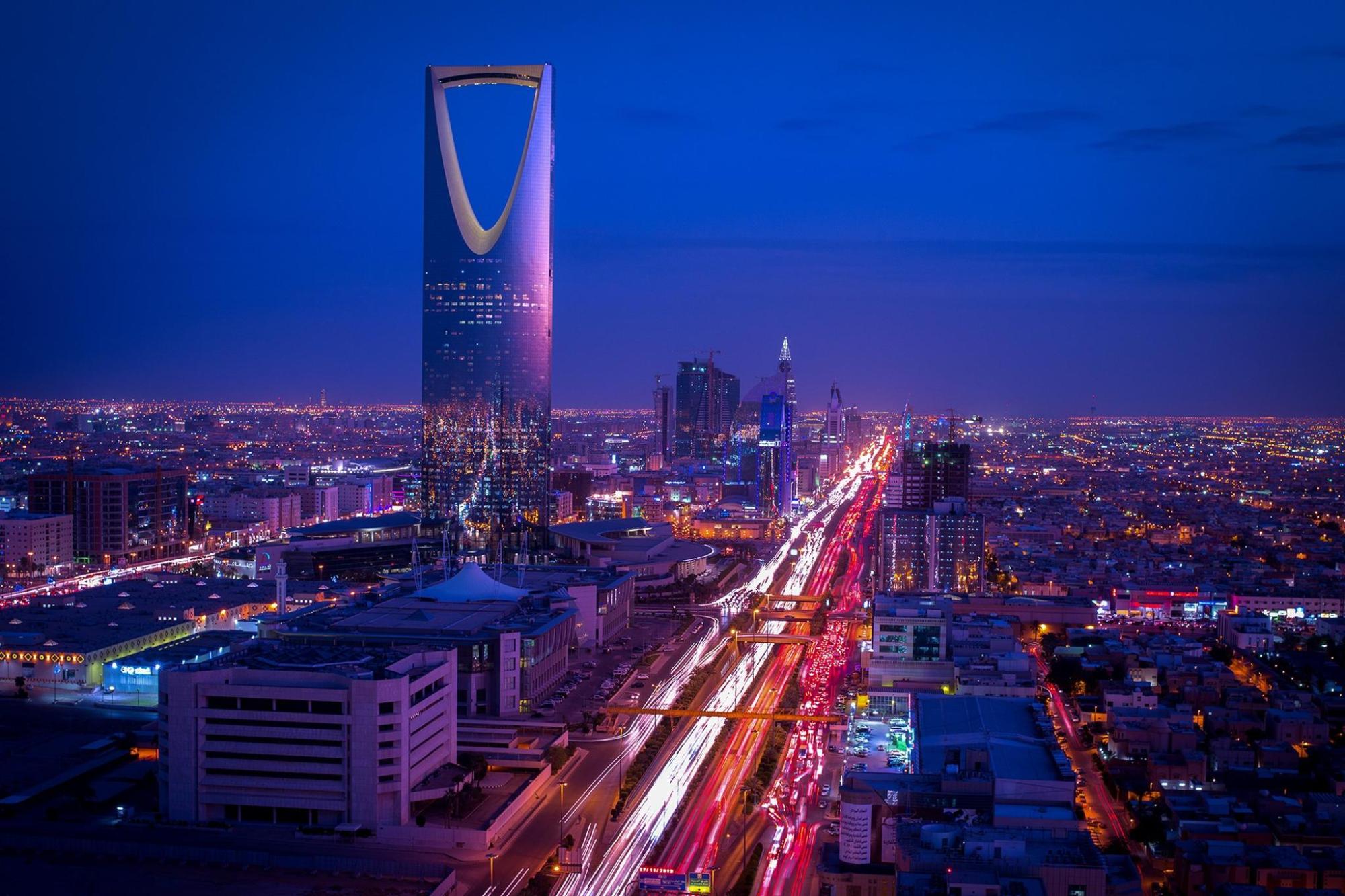 Kingdom Centre Tower rises over Riyadh's skyline at night.
