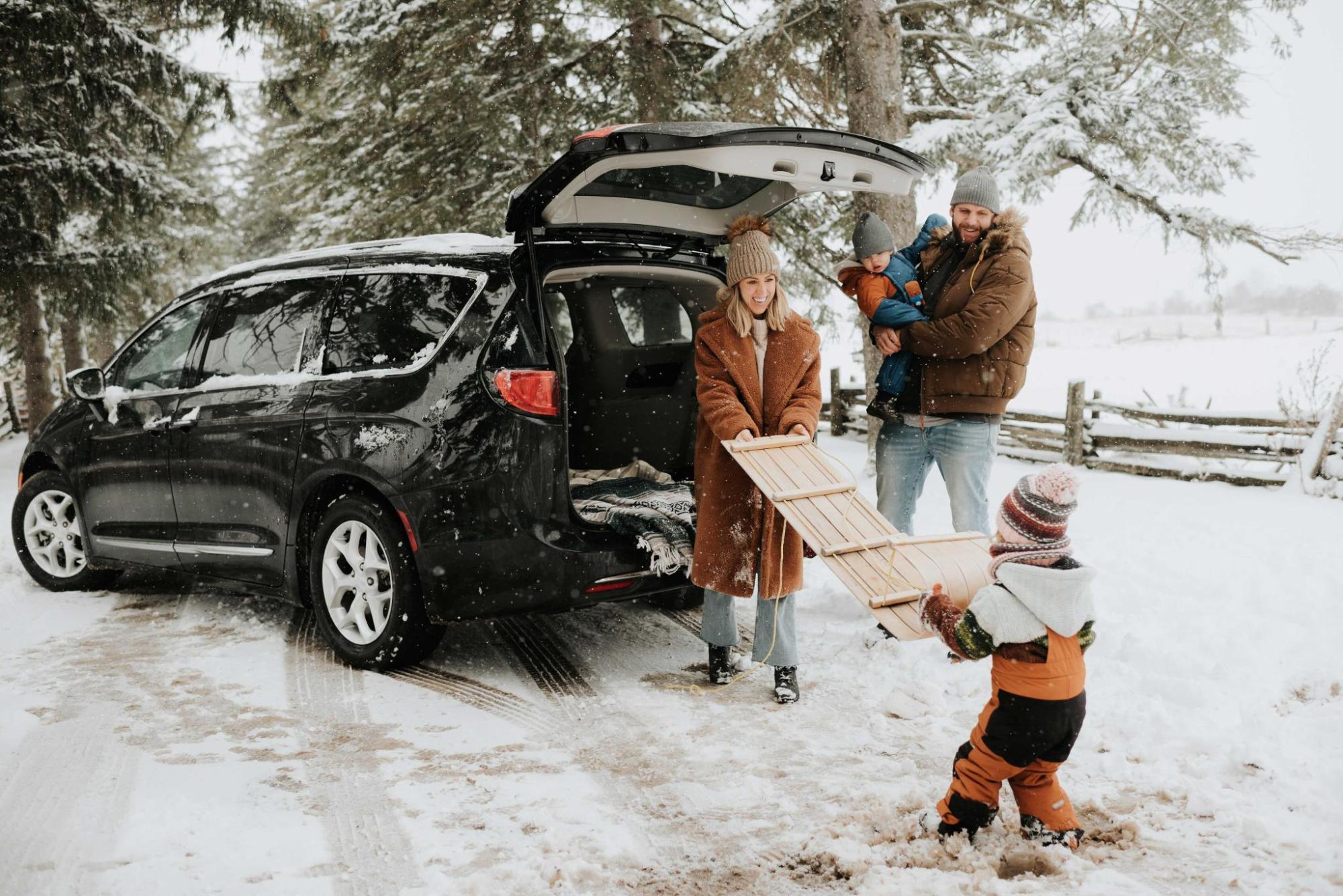 Une famille décharge un traîneau du coffre d'une voiture