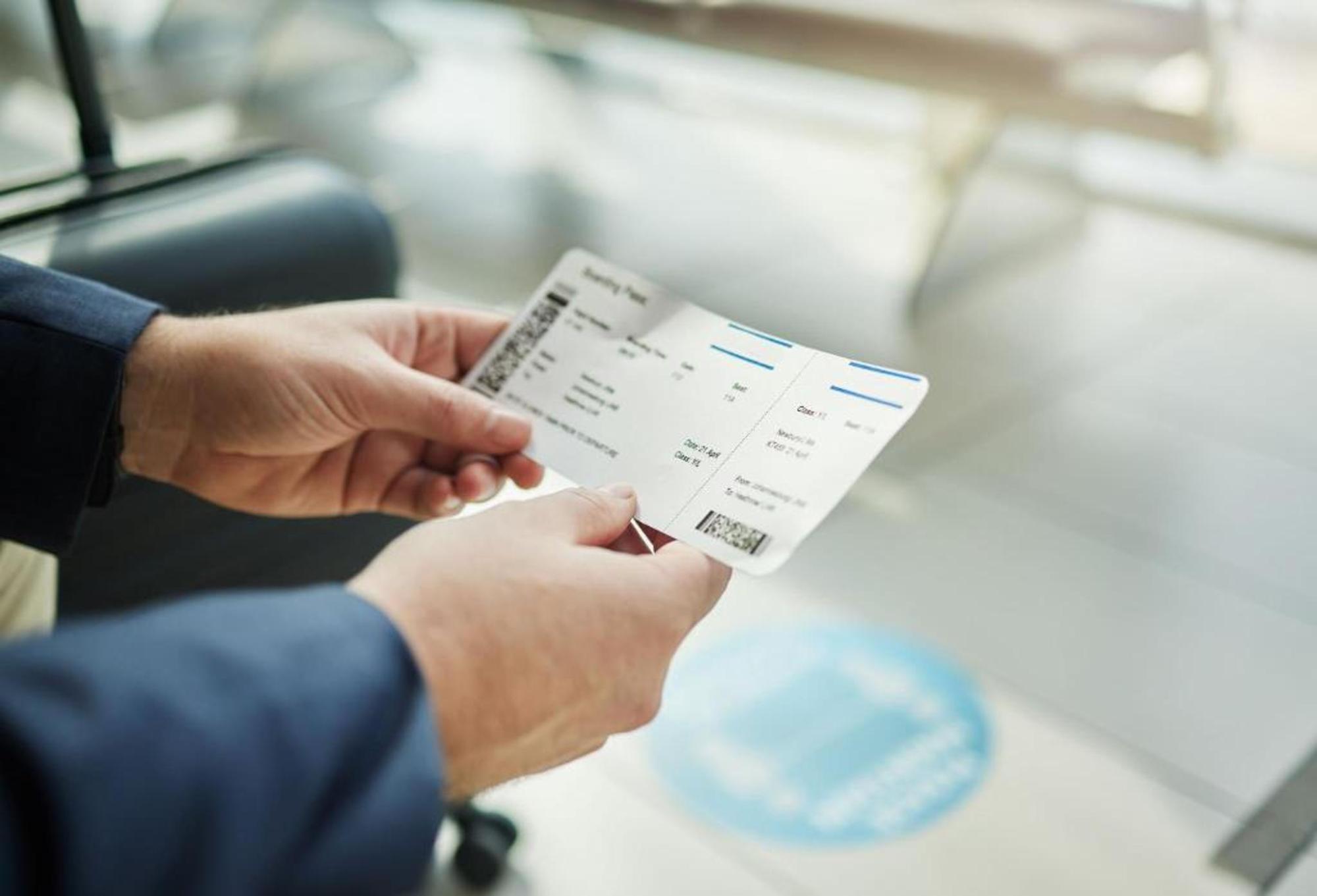 A person holding their boarding pass at the airport